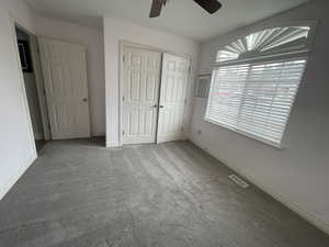 Unfurnished bedroom with baseboards, carpet floors, visible vents, and a closet