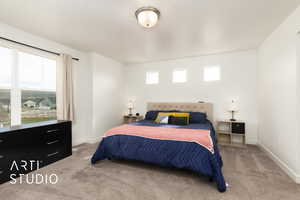 Carpeted bedroom with baseboards and multiple windows