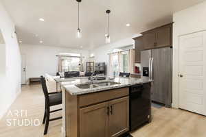 Kitchen featuring black dishwasher, a sink, stainless steel fridge with ice dispenser, and a healthy amount of sunlight