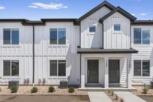 View of front of house featuring board and batten siding and central air condition unit