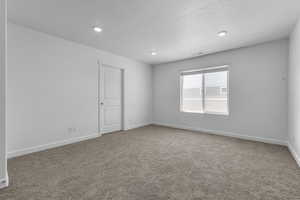 Unfurnished room with carpet flooring, a textured ceiling, visible vents, baseboards, and recessed lighting