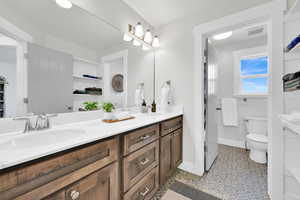 Full bathroom with double vanity and toilet