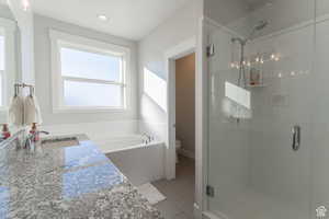 Full bathroom with toilet, vanity, a garden tub, a shower stall, and tile patterned flooring