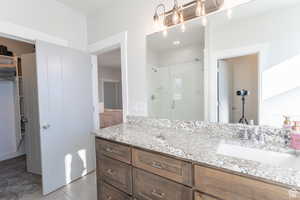 Bathroom featuring tile patterned floors, vanity, a stall shower, and ensuite bath