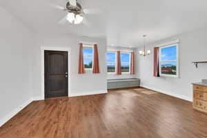 Unfurnished living room with a chandelier, wood finished floors, ceiling fan, and recessed lighting