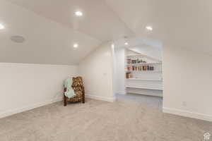 Media room featuring carpet flooring, baseboards, built in shelves, recessed lighting, and vaulted ceiling