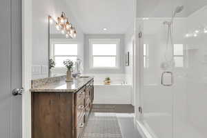 Bathroom featuring a stall shower, vanity, a garden tub, and tile patterned floors