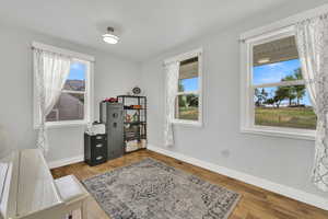 Home office with baseboards and wood finished floors