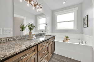 Bathroom with double vanity, a bath, tile patterned floors, and recessed lighting