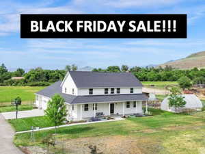 Farmhouse-style home with a porch, driveway, and a garage