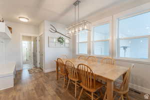Dining room with dark wood-type flooring, baseboards, and visible vents
