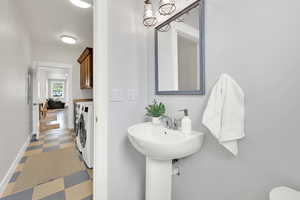 Bathroom featuring independent washer and dryer and tile patterned floors