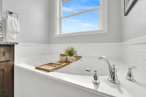Full bath featuring a garden tub and vanity