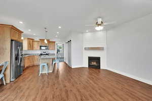 Kitchen featuring stainless steel appliances, open floor plan, a barn door, recessed lighting, and wood finished floors