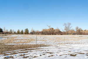 Yard covered in snow with a rural view