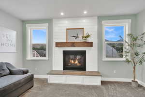 Living area featuring carpet, a large fireplace, and recessed lighting