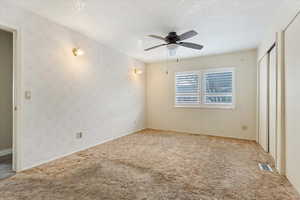 Unfurnished bedroom featuring baseboards, visible vents, wallpapered walls, and carpet floors