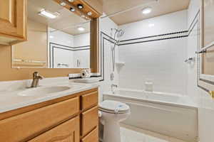Full bath featuring tile patterned floors, vanity, toilet, and washtub / shower combination