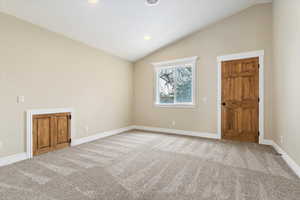 Carpeted spare room featuring baseboards, lofted ceiling, and recessed lighting
