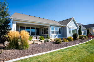 Back of house featuring a lawn, board and batten siding, and roof with shingles