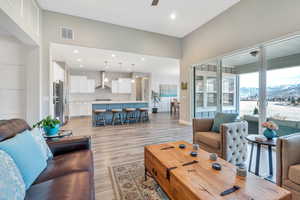 Living room featuring recessed lighting, light wood-style floors, ceiling fan, and visible vents
