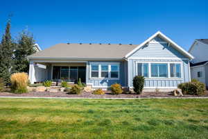 Back of property with board and batten siding and a lawn
