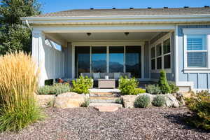 Entrance to property with an outdoor living space and a shingled roof