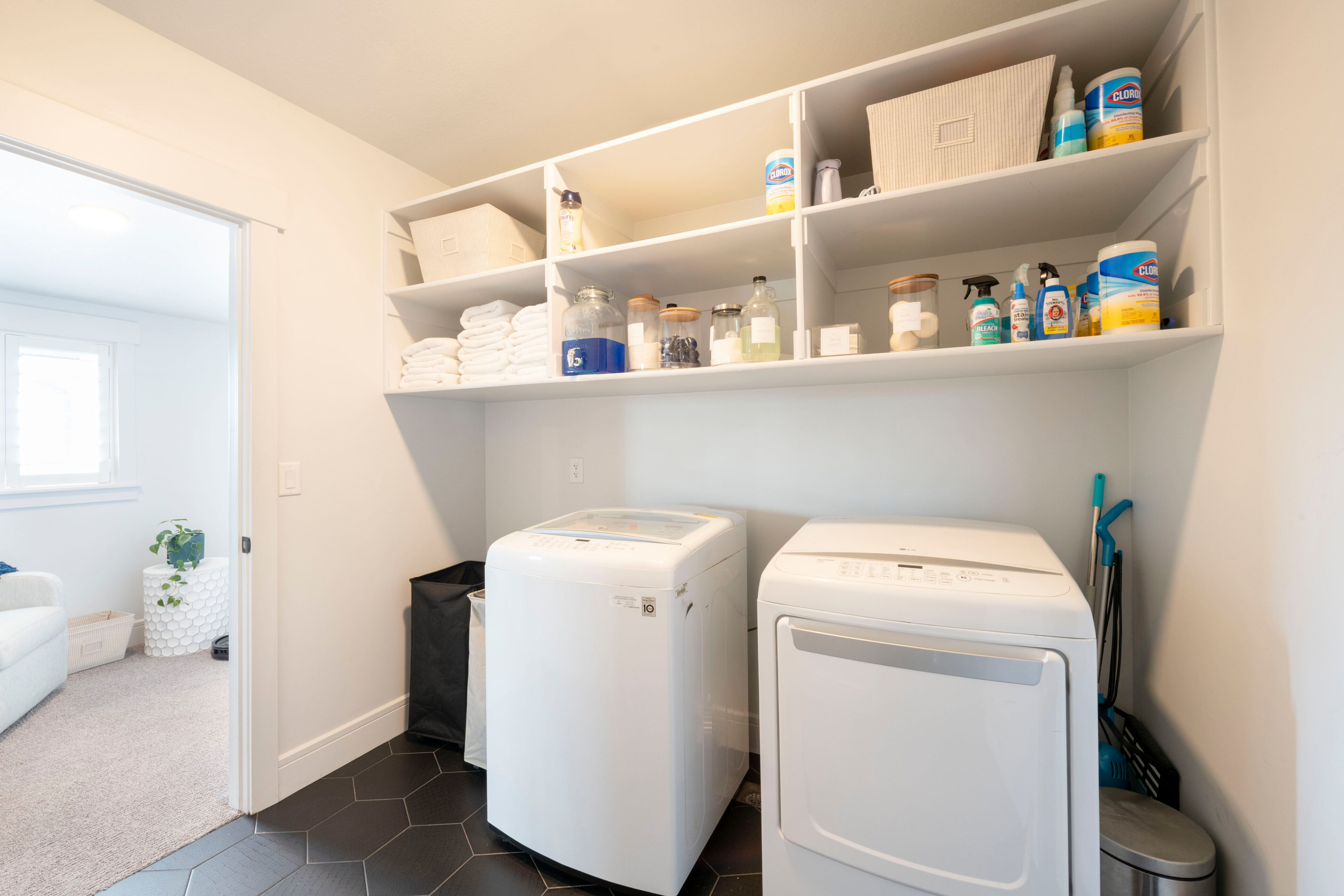 Laundry area with independent washer and dryer, dark tile patterned floors, baseboards, laundry area, and dark colored carpet