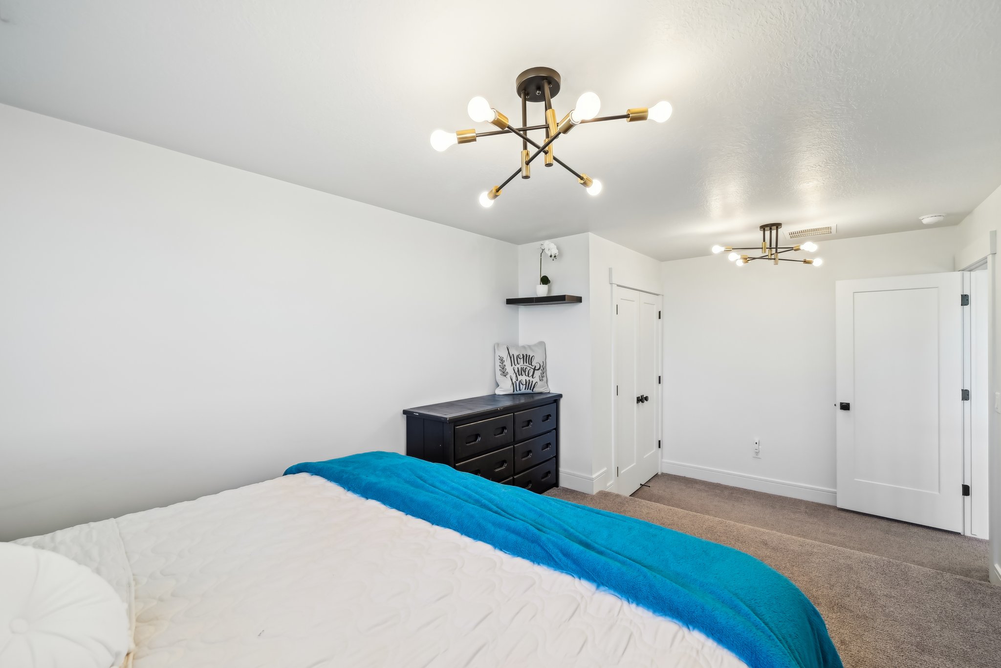 Carpeted bedroom with baseboards and a chandelier