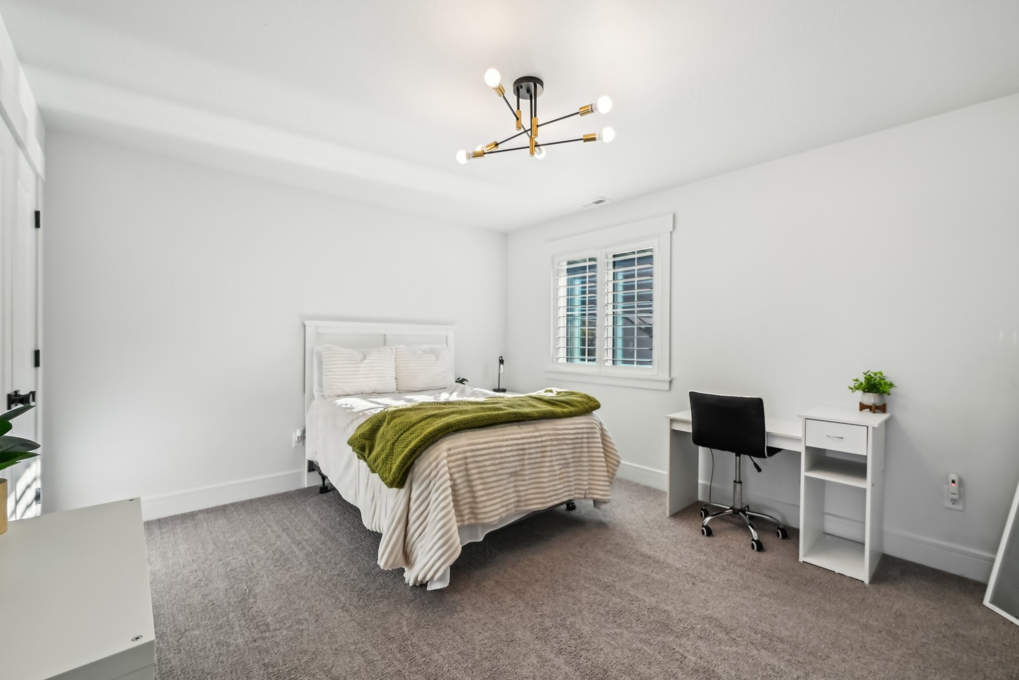 Carpeted bedroom featuring a notable chandelier and baseboards