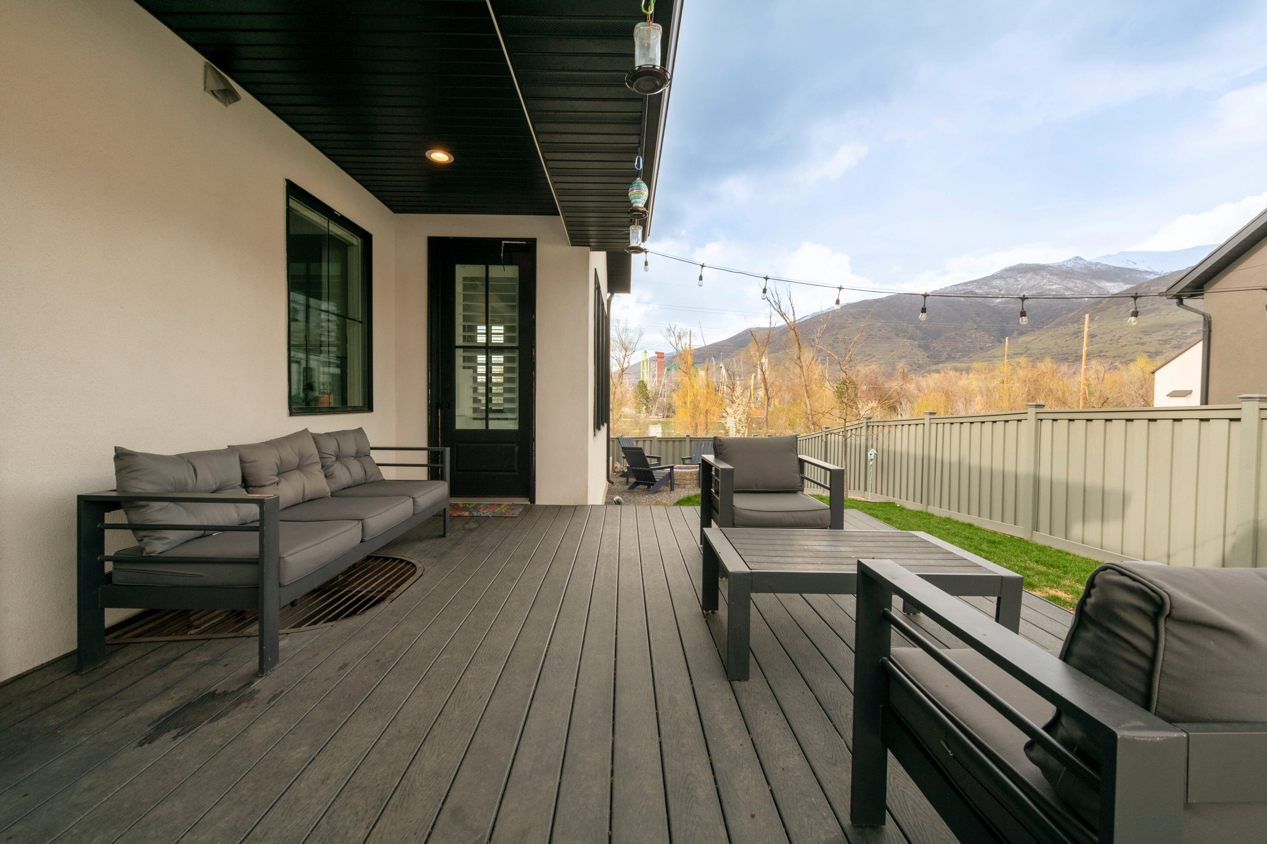 Wooden deck with an outdoor hangout area, a mountain view, and fence