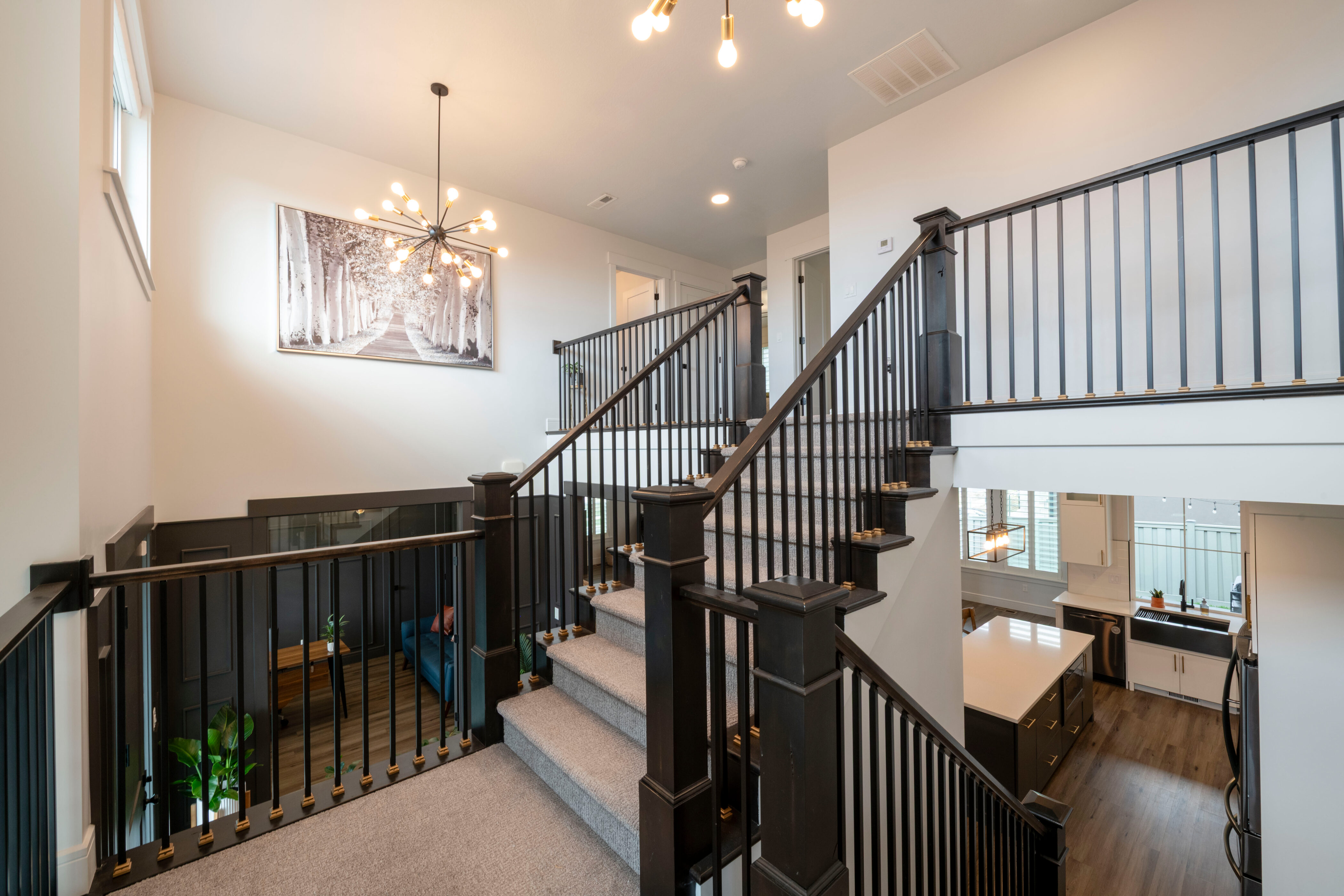 Staircase with visible vents, wood finished floors, and a notable chandelier
