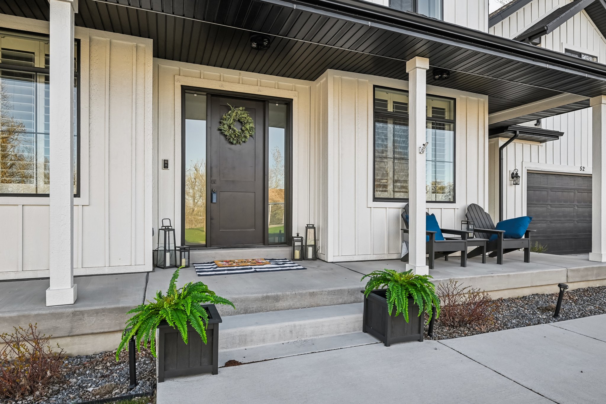 Entrance to property featuring a garage, board and batten siding, and covered porch