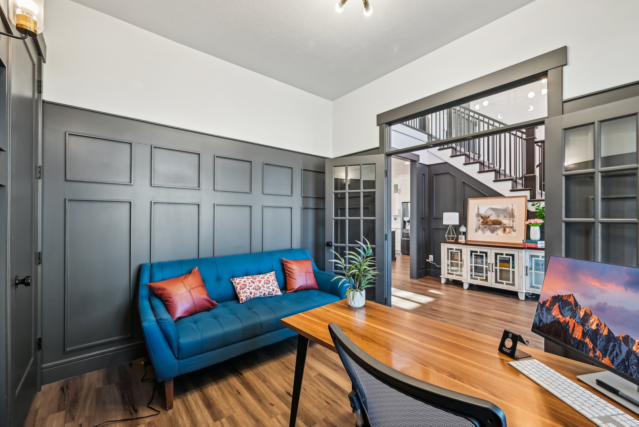 Living area featuring stairs, a towering ceiling, a decorative wall, and wood finished floors