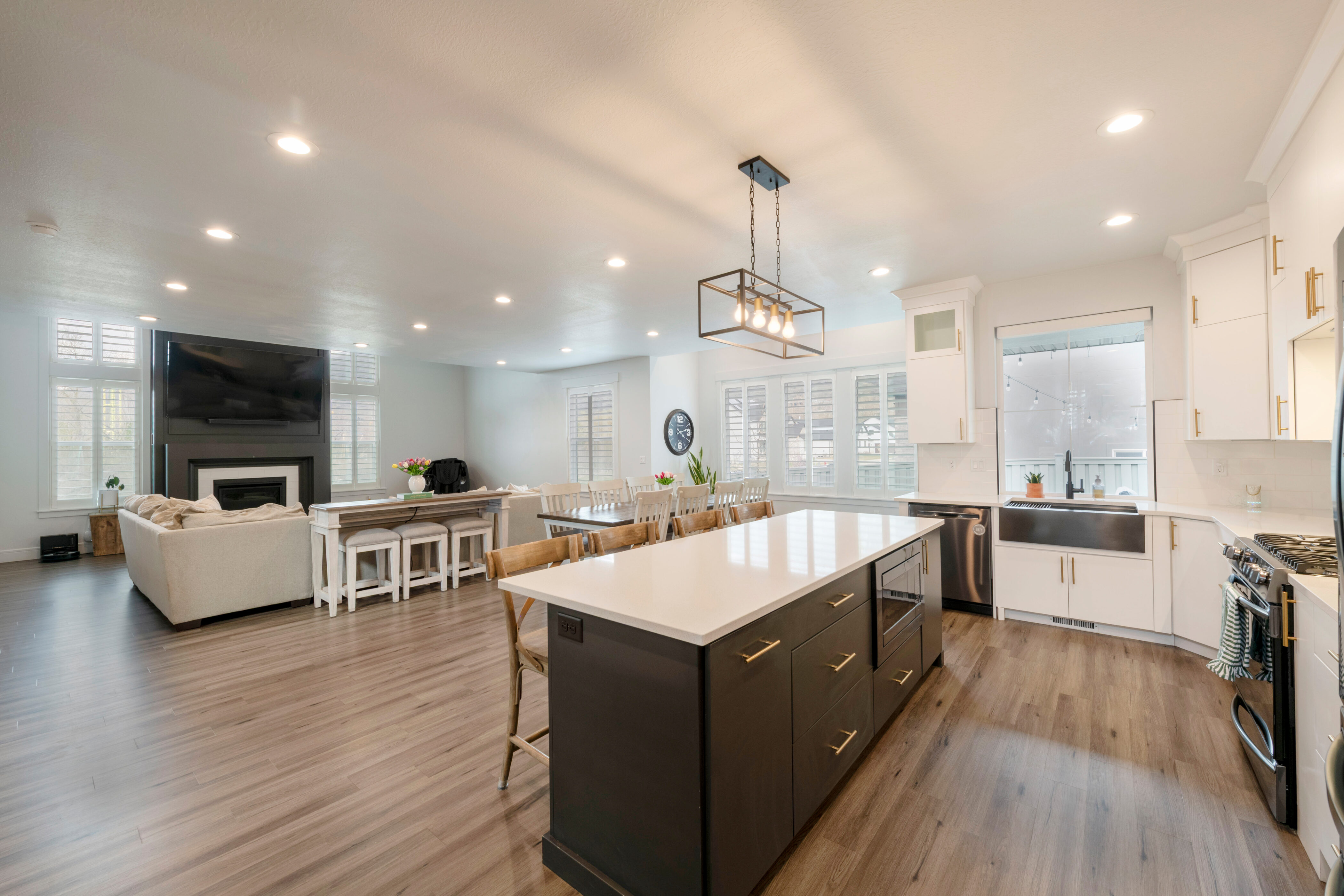 Kitchen with white cabinets, light countertops, appliances with stainless steel finishes, a sink, and a kitchen breakfast bar