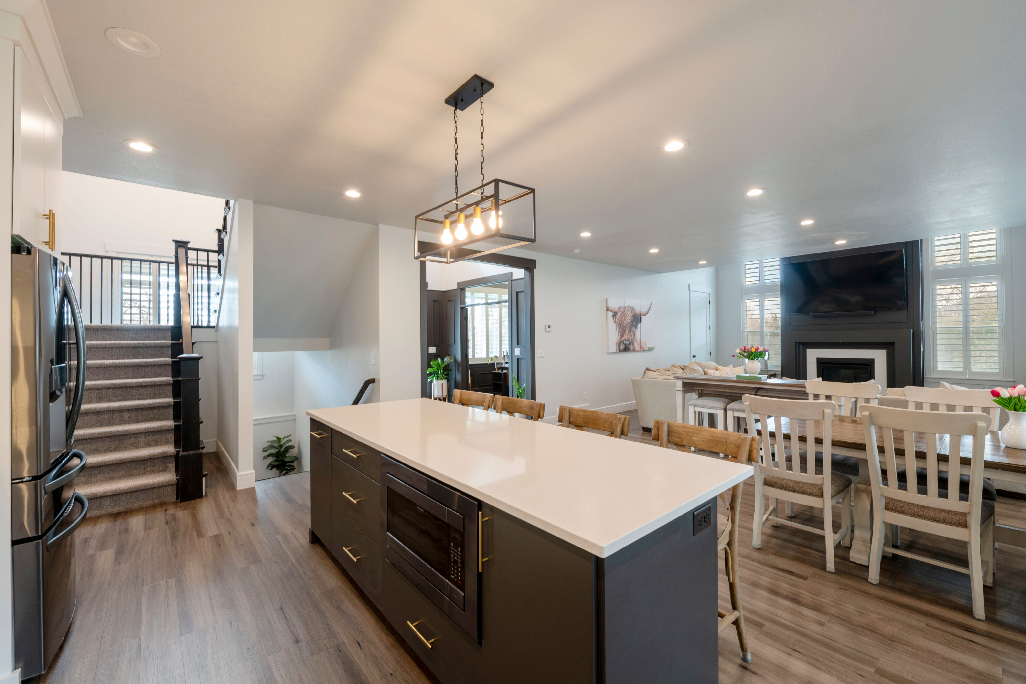 Kitchen with a kitchen breakfast bar, dark wood-style floors, a kitchen island, and appliances with stainless steel finishes