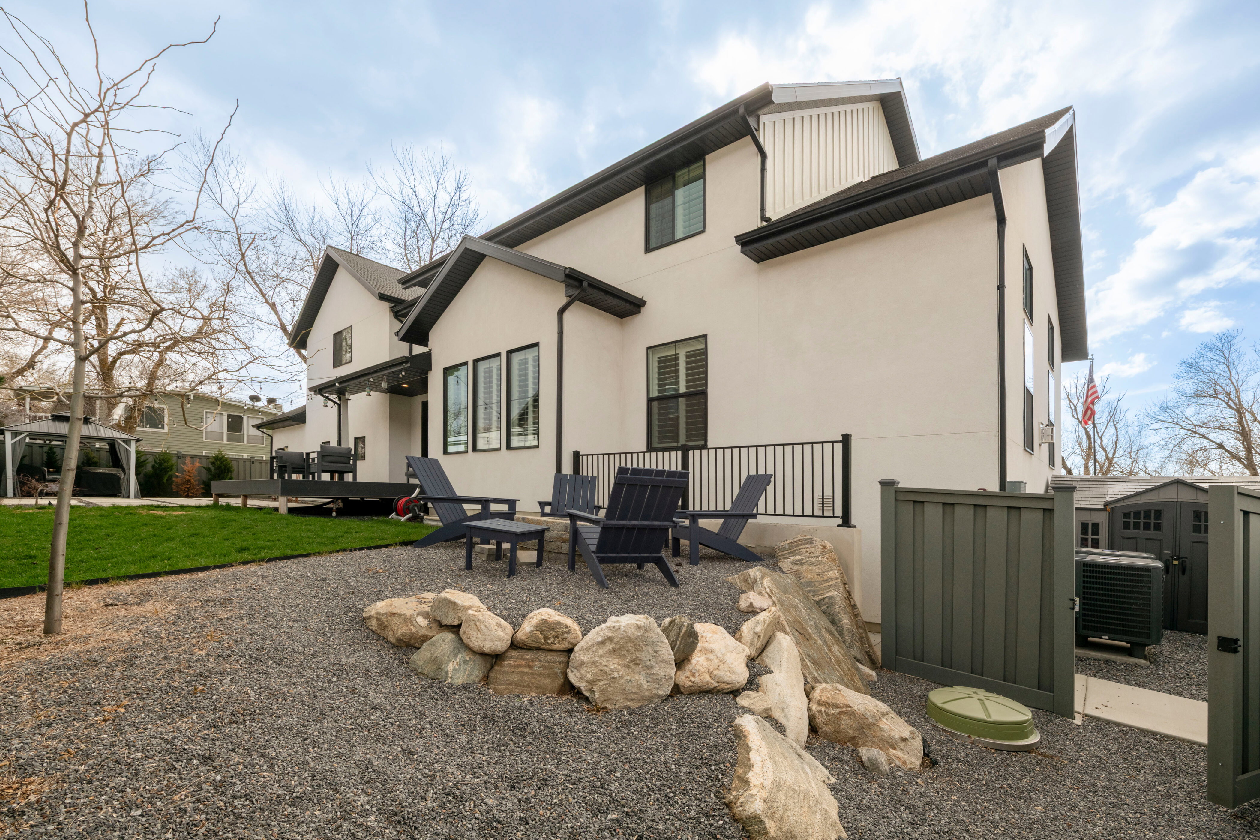 Rear view of property featuring an outdoor structure, stucco siding, a patio, central AC unit, and a yard