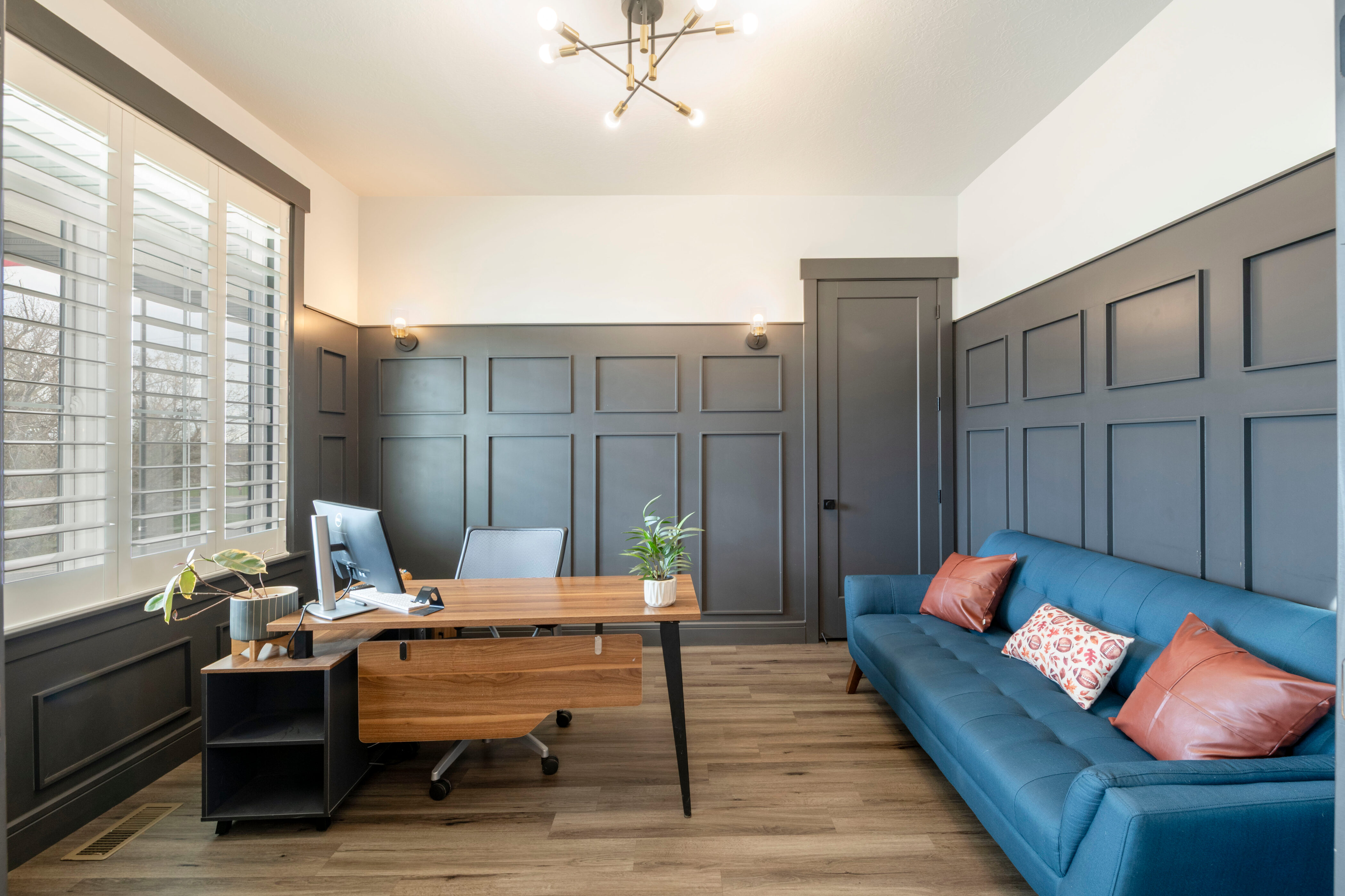 Home office featuring a decorative wall, a notable chandelier, light wood-style floors, and visible vents