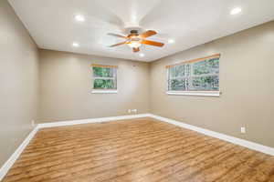 Unfurnished room featuring wood finished floors, baseboards, a ceiling fan, and recessed lighting