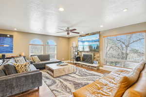 Living area featuring a textured ceiling, wood finished floors, and a ceiling fan