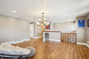Sitting room featuring visible vents, baseboards, an inviting chandelier, and wood finished floors