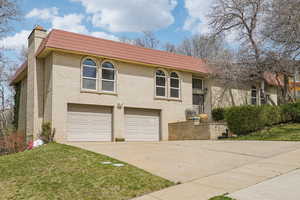Raised ranch featuring brick siding and mansard roof