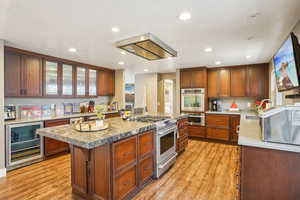 Kitchen featuring recessed lighting, a sink, beverage cooler, stainless steel appliances, and light wood finished floors