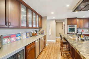 Kitchen with recessed lighting, light wood-type flooring, a sink, and exhaust hood