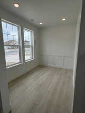 Flex Room with light wood finished floors, recessed lighting, Natural light and a decorative wall