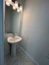 Half Bathroom with marble finish flooring