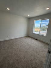 Bedroom with carpet, tall baseboards and recessed lighting