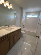 Main Bathroom featuring marble look tile flooring, vanity, bathtub / shower combination, and recessed lighting