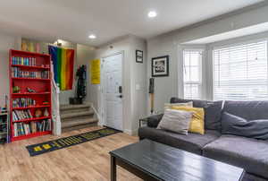 Living room with baseboards, recessed lighting, wood finished floors, and ornamental molding