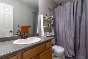 The upstairs hall full bathroom features a tub/shower combo and a large vanity and mirror with toilet.